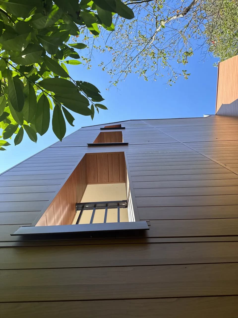 Composite wood siding on a tall residential facade: Vancouver Special renovation reference