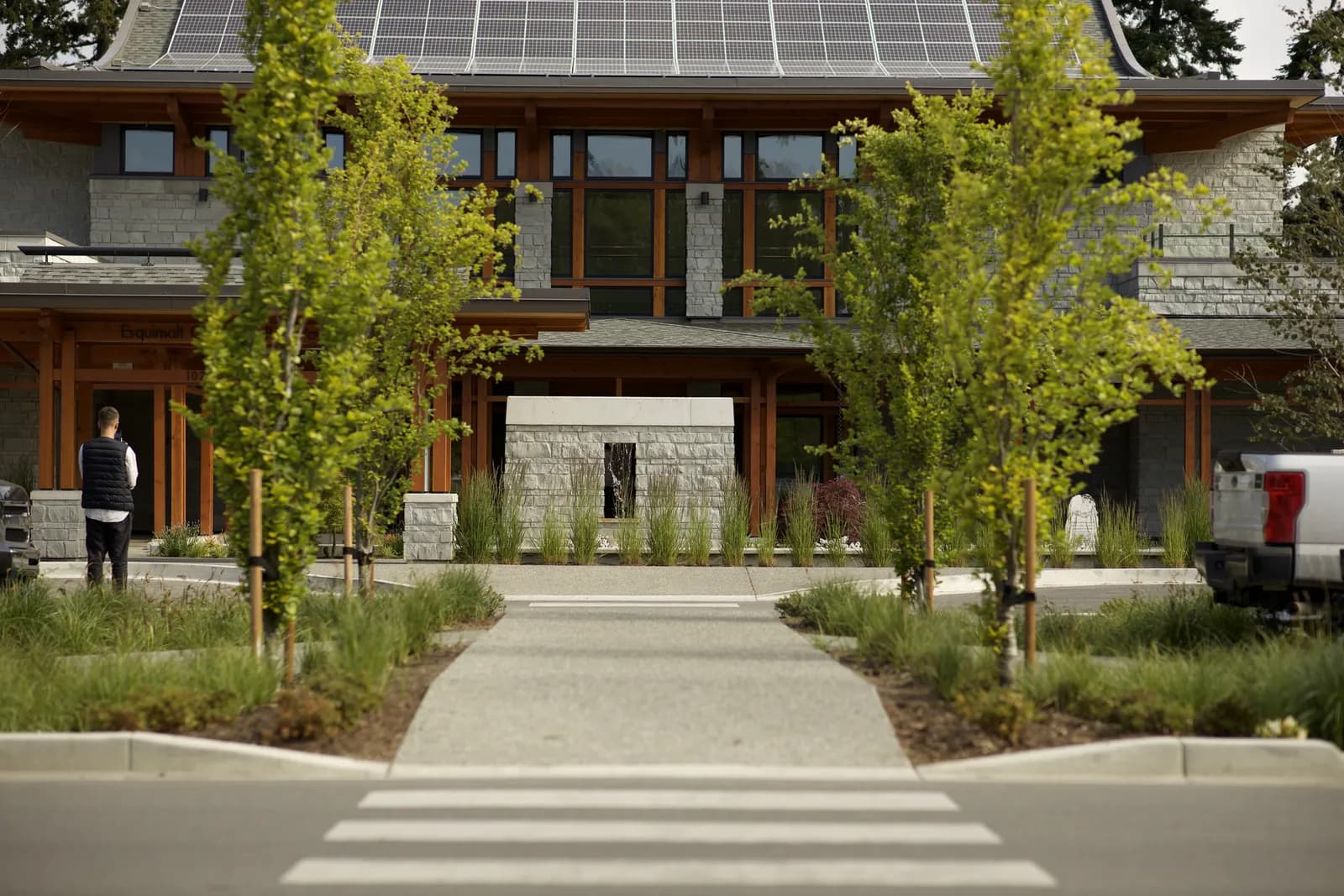 Custom BC home with stone facade, timber posts, and rooftop solar — energy-efficient renovation BC reference