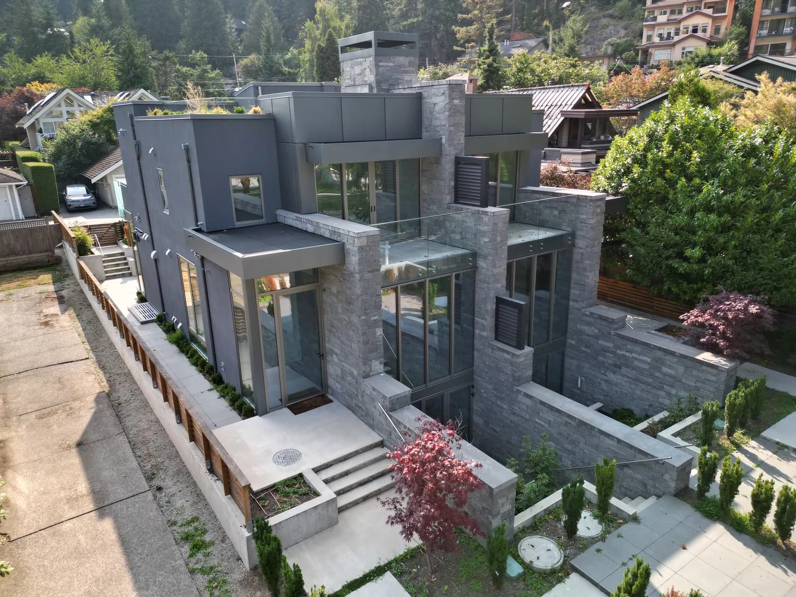 Modern waterfront custom home with stone and glass facade — coastal exterior renovation Delta BC