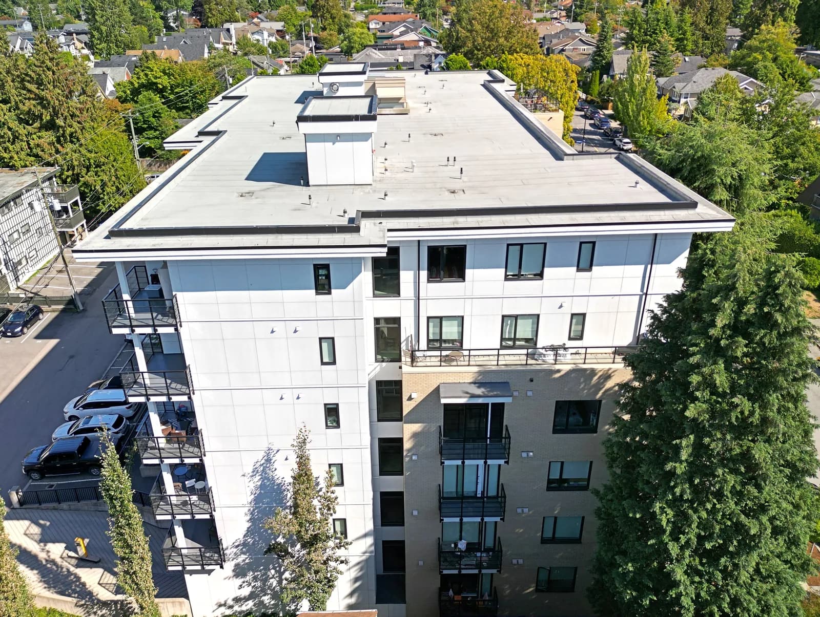 Modern white panel mid-rise residential exterior — EIFS-style finish on a BC multi-family building